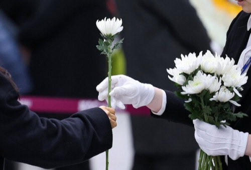 무안공항 제주항공 여객기 참사 일주일째를 맞은 4일 전남 무안국제공항 여객터미널에 마련된 합동분양소에서 시민들이 국화꽃을 받아들고 있다.