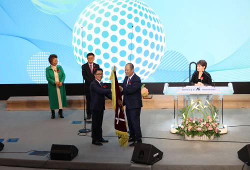 OC연합회 한성준 신임회장이 김도영신임이사장과 이임하는 민김 권사가 지켜보는 가운데 이임하는 신용회장으로 부터 회기를 받아들고 있다.