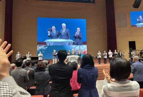 미주성시회운동 본부 공동대표 송정명 목사가 새로 추대되는 한기홍 목사에게 공동대표회장 추대패를 전달하며 축하하고 있다. 