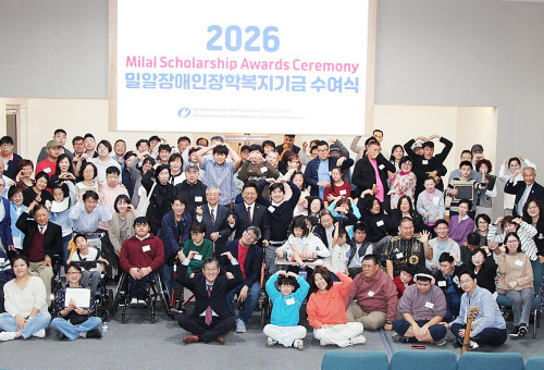 2026밀알장애인장학복기기금 수여식을 마친 후 참석자들이 기념촬영을 하며 사랑의 인사를 하고있다. 맨 앞 가운데 앉은 이가 이종희단장, 세번째 줄 가운데가 이사장 이중열장로이다.